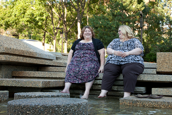 Two women sat with feet in water course