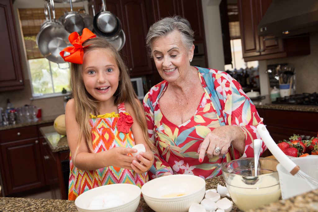 Older woman cooking with grand daughter